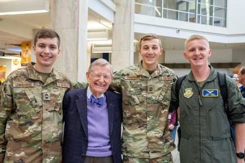 President Gee poses for a photo with three students wear Air Force uniforms.