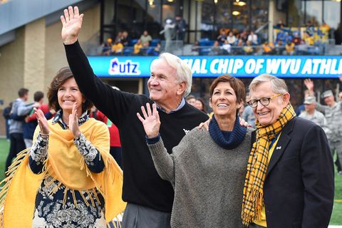 Cindi Roth, Verl and Sandy Purdy, and President Gee on the field at Milan Puskar Stadium