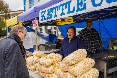 President Gee looks over the stack of kettle corn bags while visiting Mountaineer Week vendors.
