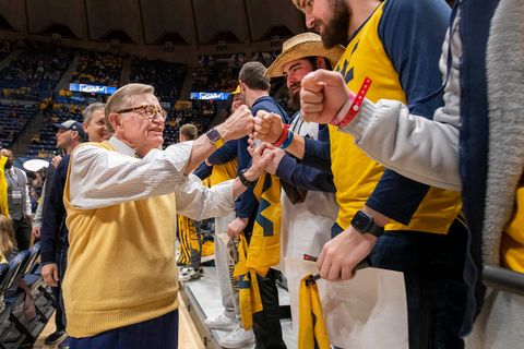 President Gee shares a fist bump with a student in the WVU student section inside the Coliseum. 