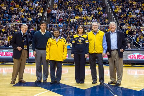President Gee stands on the Coliseum floor with 2014 Distinguished Alumni inductees.
