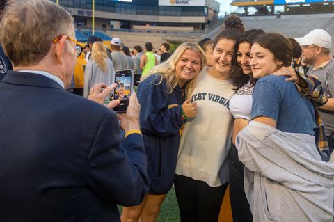 President Gee takes a picture for a group of four students.