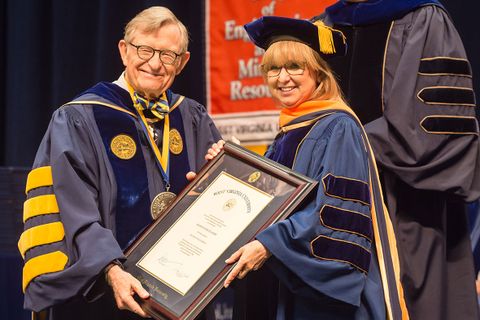 President Gee hands a large framed certificate to Sharon Flanery